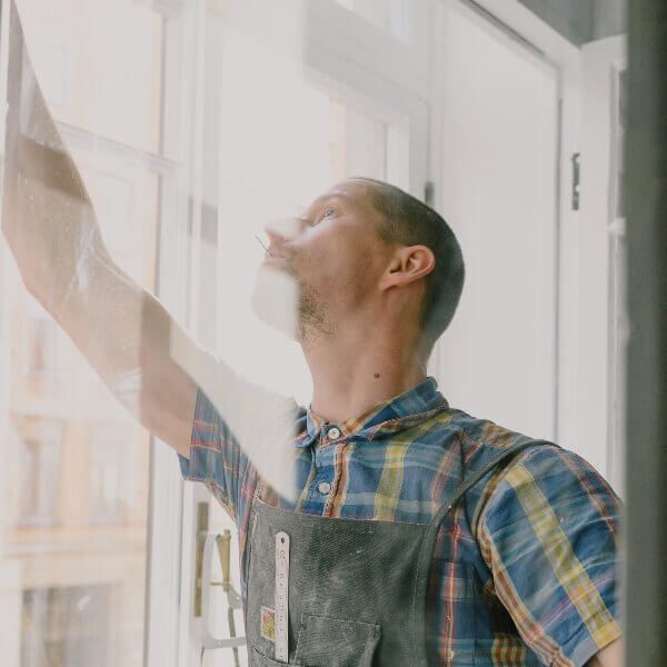 Person cleaning a large window