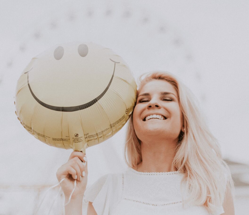 Woman smiling with a smiley balloon