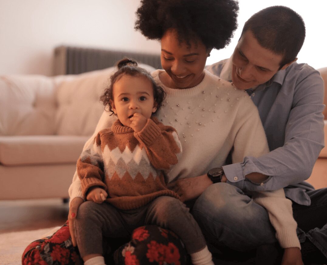 Parents smiling with their child indoors