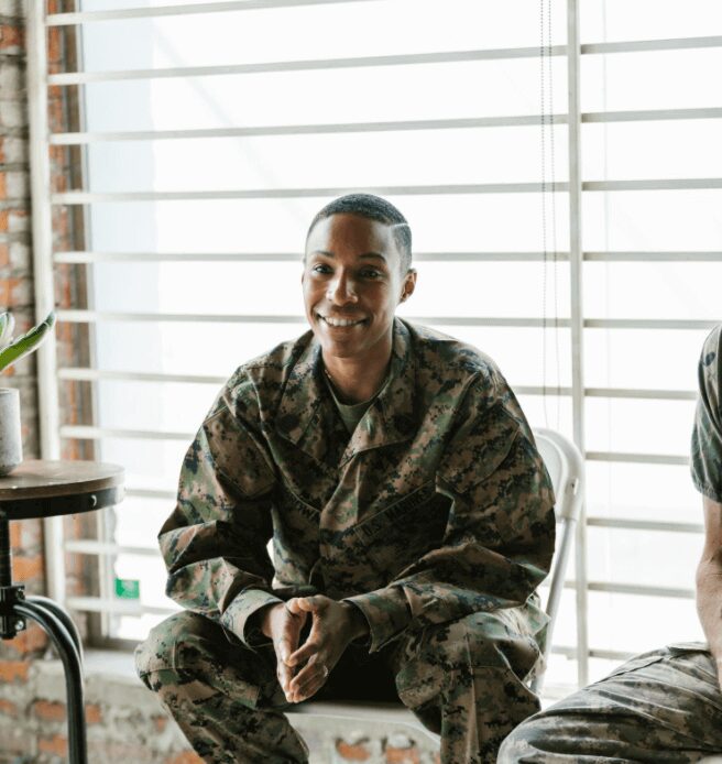 Happy military personnel seated by a table