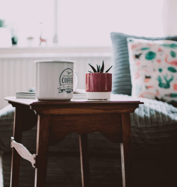 Coffee mug and plant on wooden table