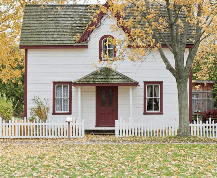 White house with red trim in autumn