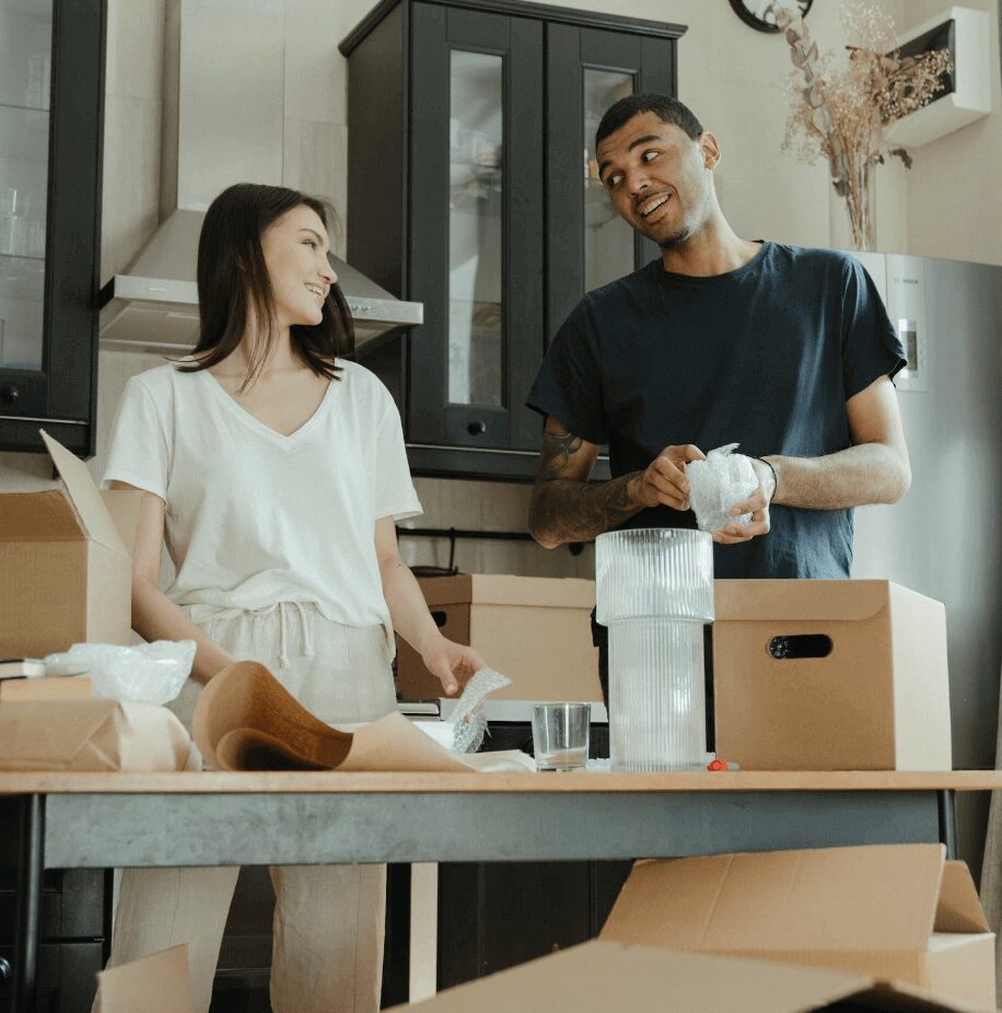 Couple unpacking boxes in kitchen