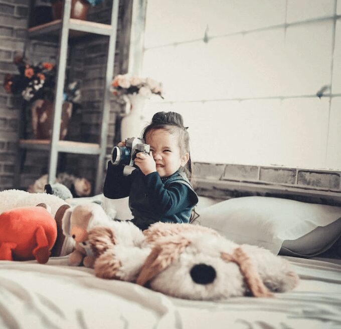 Toddler enjoying photography with plush toys