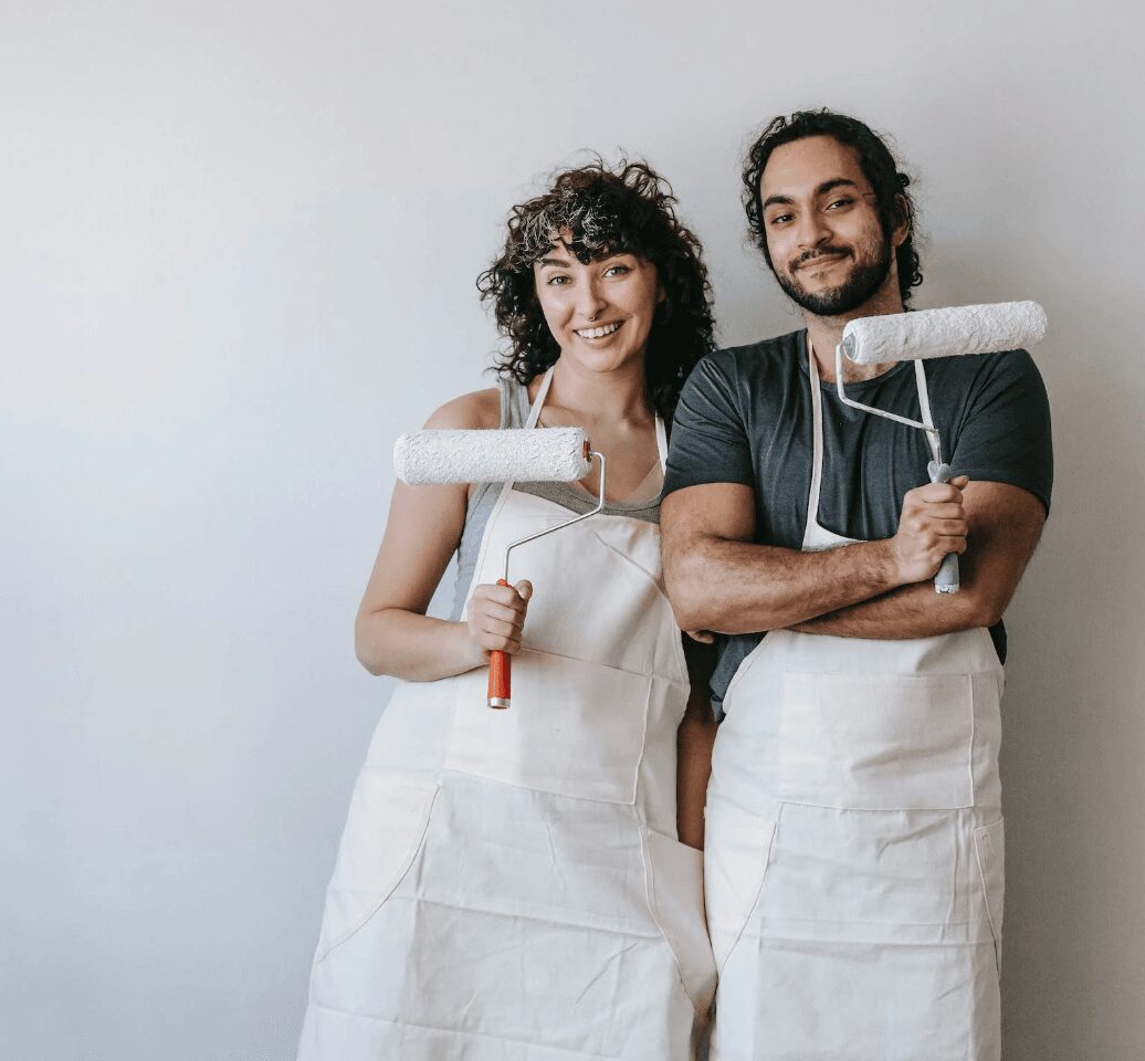 Couple smiling with paint rollers