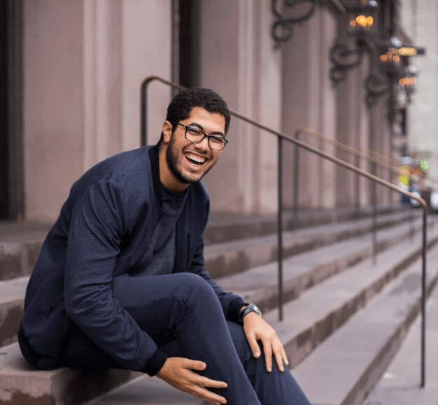 Man smiling while sitting on steps