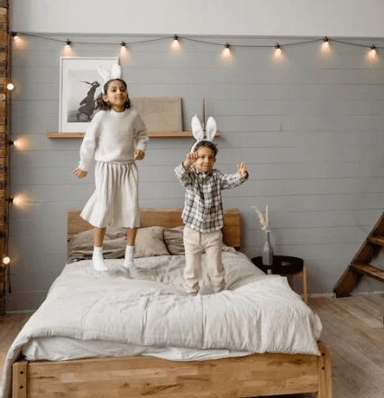 Siblings having fun on a cozy bed