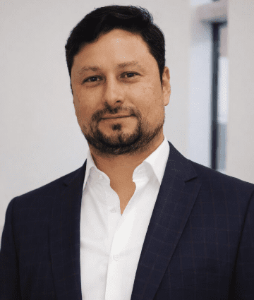 Professional man in a dark suit smiling at the camera.